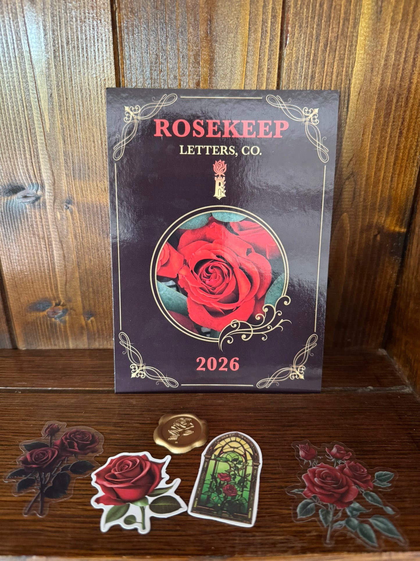 Rosekeep 2026 postcard with decorative stickers on a wooden surface