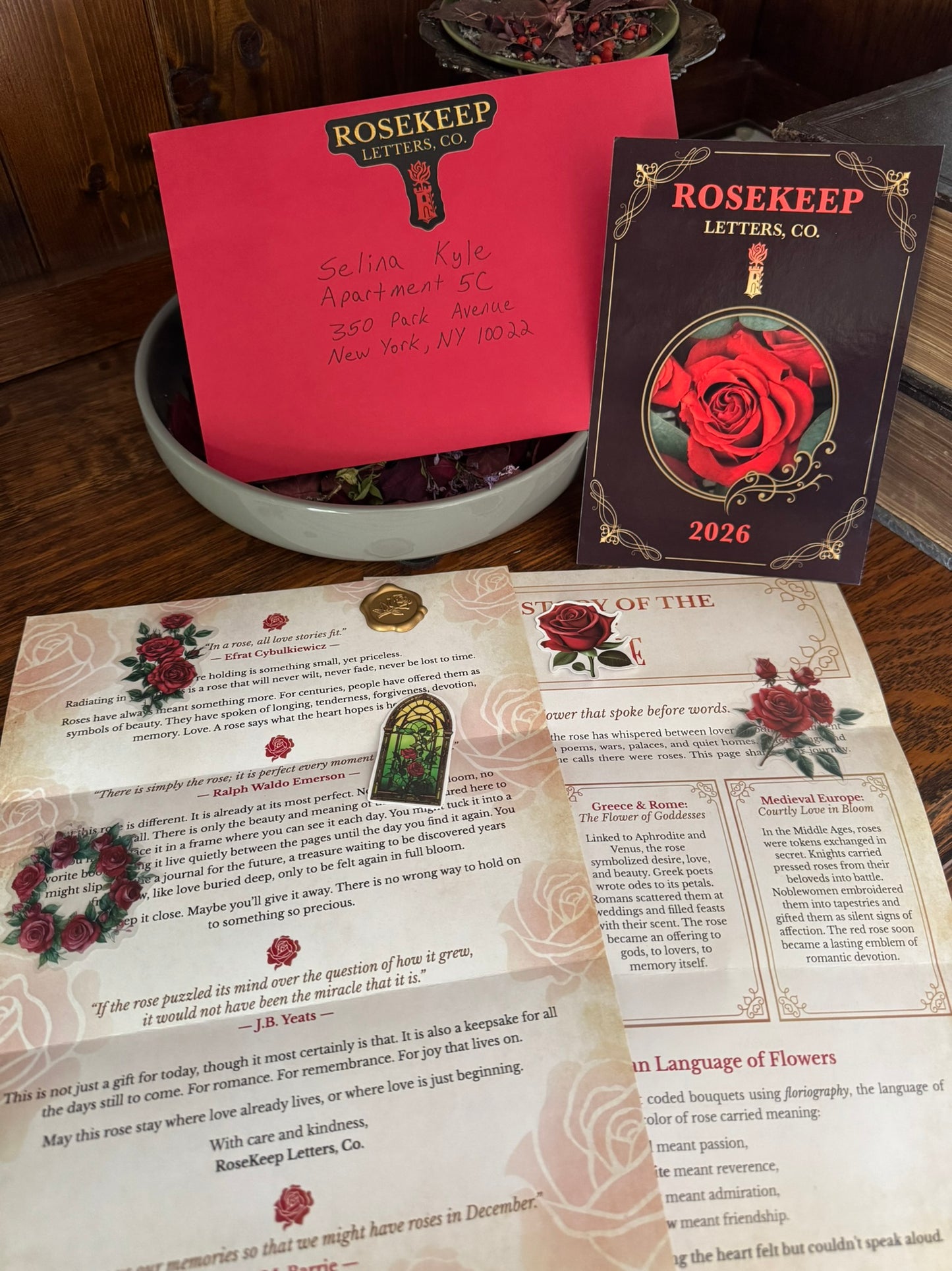 Rosekepe Letters Co products including romantic postcard, book, and stationery on a wooden surface.